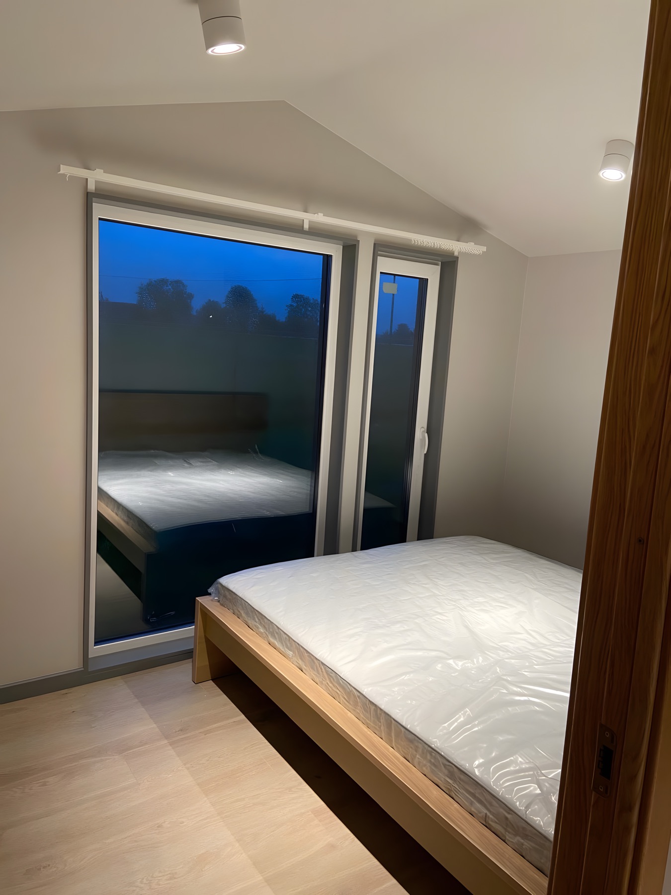 Schlafzimmer mit großem Fenster und ruhiger Abendstimmung im Polarnest.