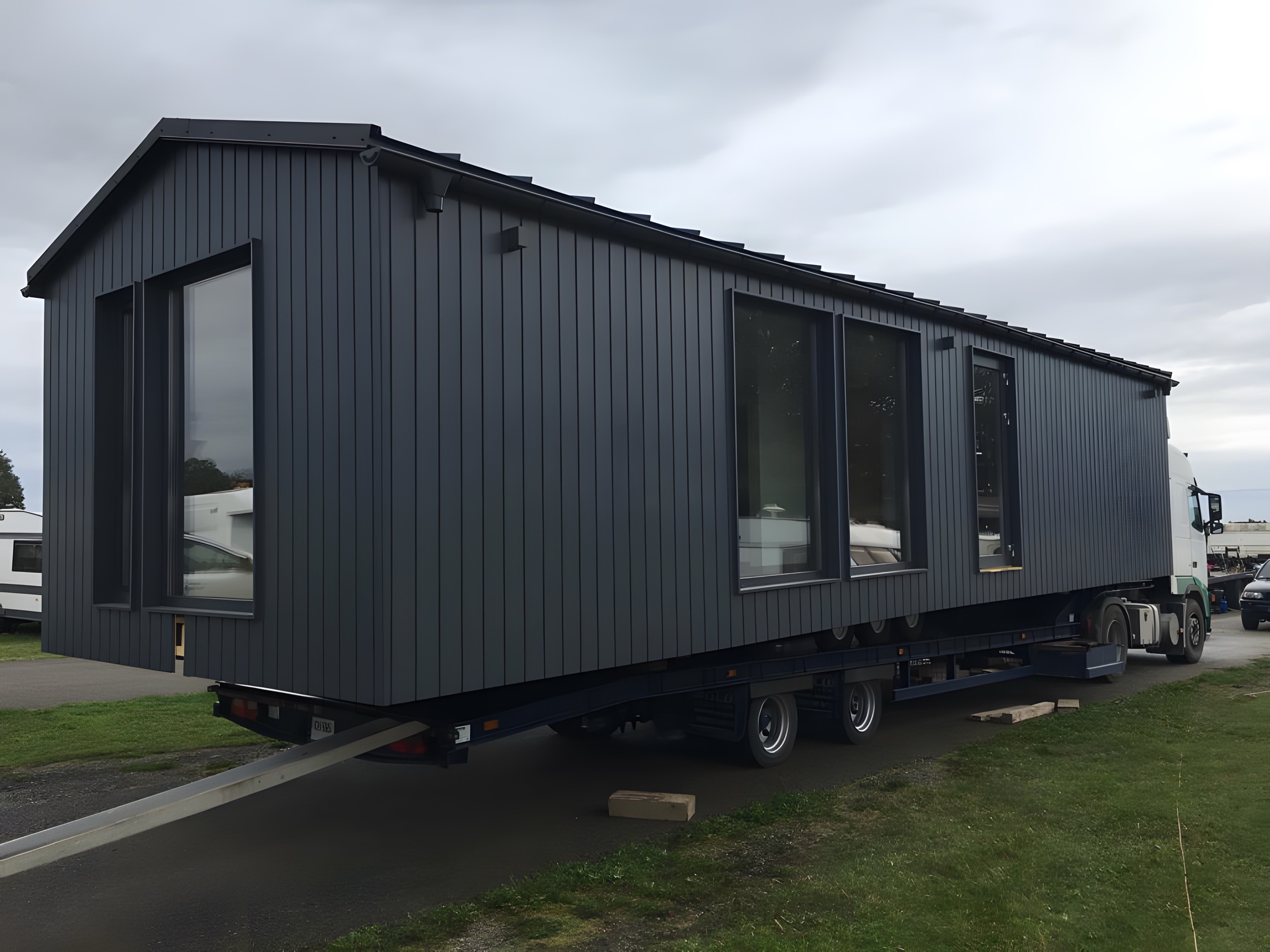 Seitliche Ansicht eines dunkel verkleideten Polarnest Hauses mit klarer Proportion.