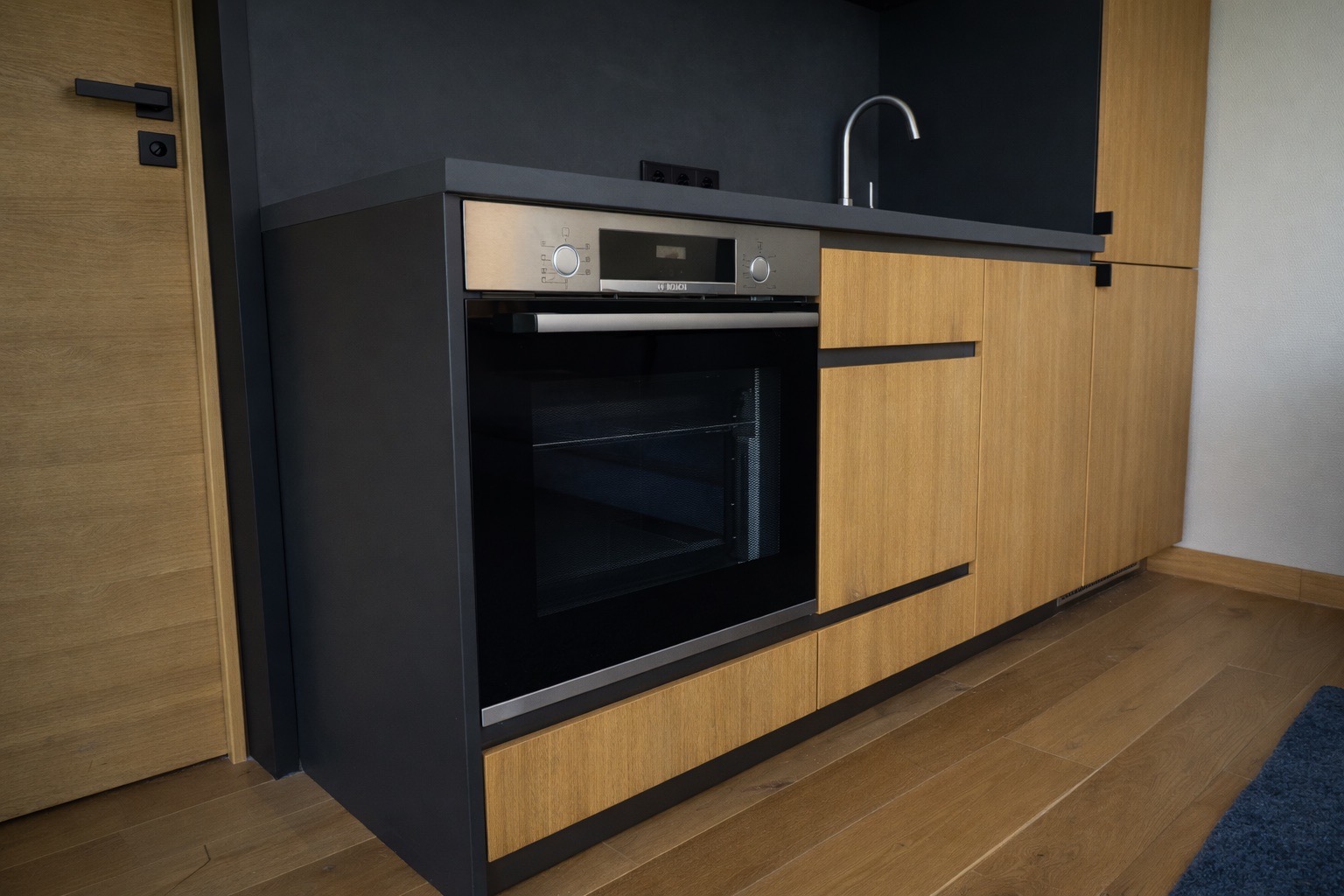 Geschlossene Küchenansicht im Tinyhouse mit durchdachtem Stauraum und warmen Materialien.