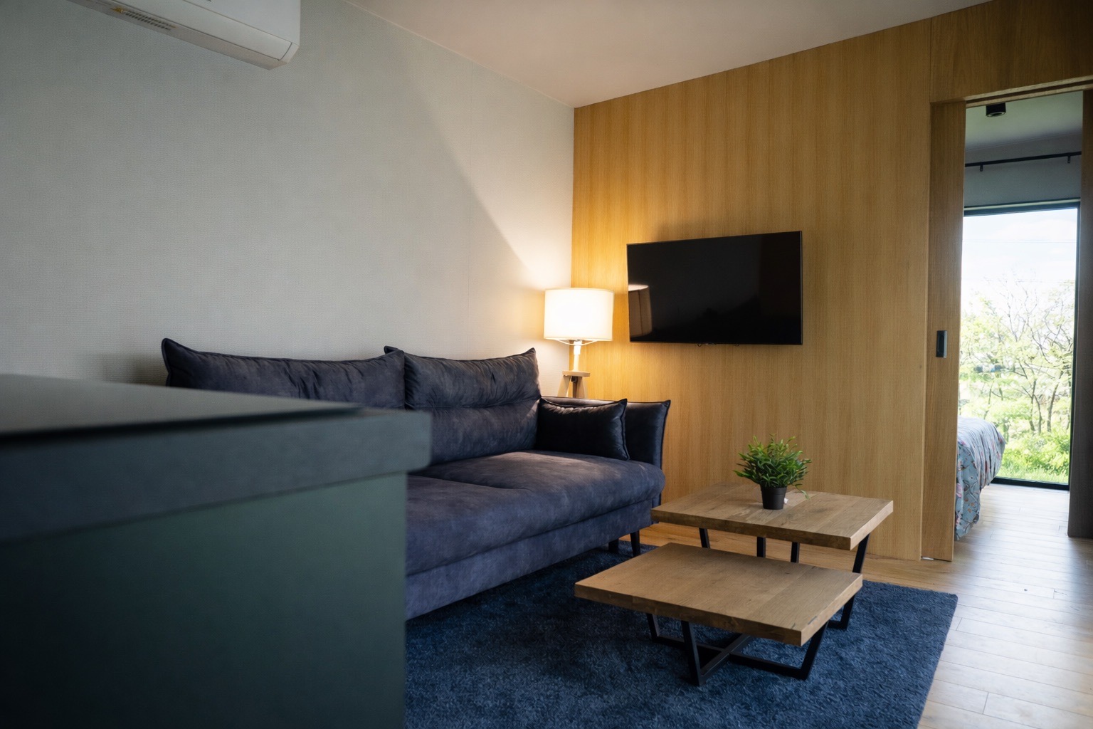 Wohnzimmer im Tinyhouse mit heller Holzoptik, Sitzbereich und ruhiger Atmosphäre.